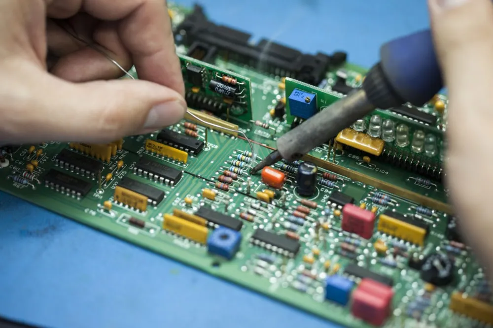 An engineer repairing an instrument circuit board at the bench